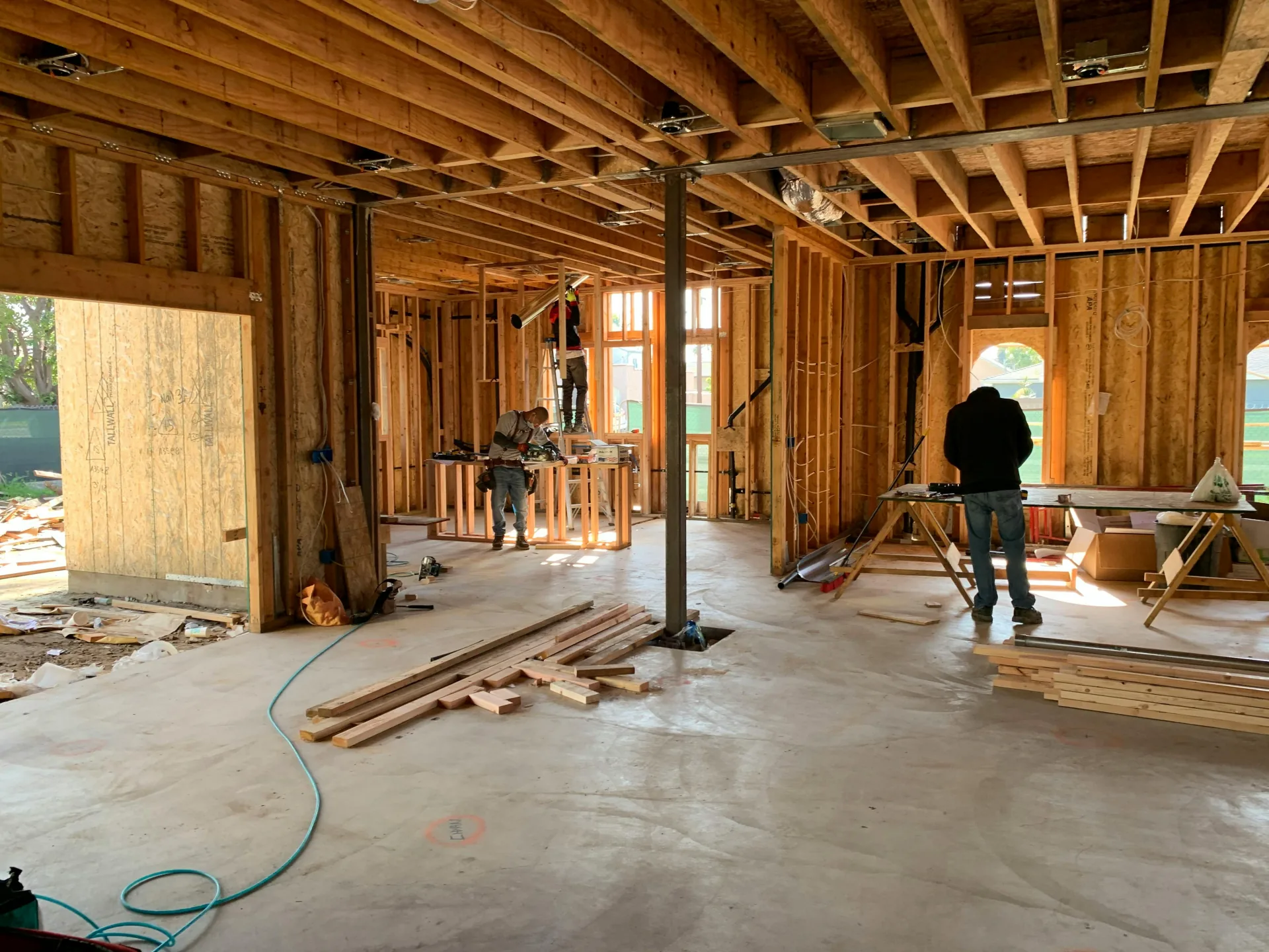 Interior of a house under construction showing exposed wood framing where blower door testing identifies air leaks